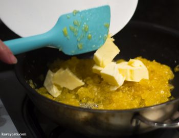 Adding butter to the cooking pineapple jam