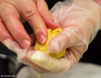 Forming pastry dough around pineapple jam filling