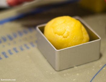 Placing rounded pineapple cake into metal mould