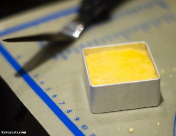 Pressing pineapple cake into metal mould, during making of Taiwanese pineapple cakes