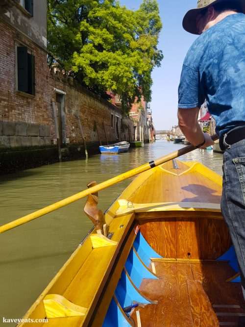 Student rowing a Row Venice batele, a narrow row boat that is similar to a Venetian gondola. 