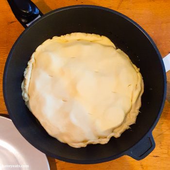 Laying pastry into pan for Tomato Tarte Tatin